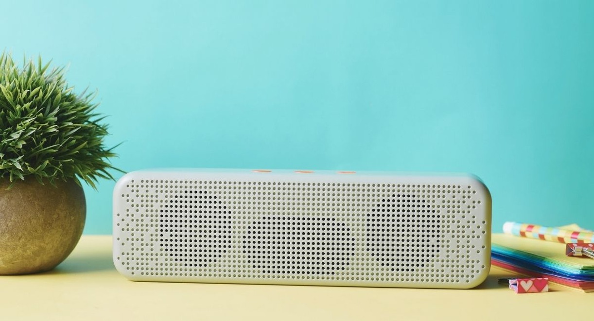 Enceinte bluetooth portable blanche posee sur un bureau colore