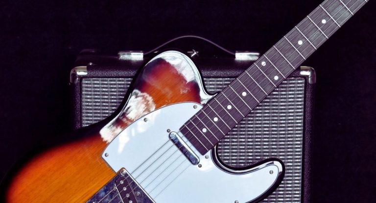 Guitare electrique a finition sunburst appuyee contre un amplificateur
