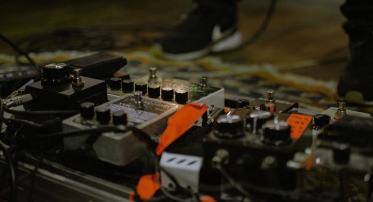 Pédalier de guitare regroupant plusieurs pédales d'effet posé au sol sur scène